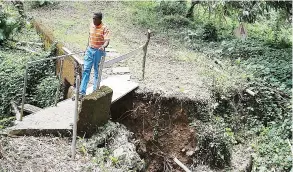  ??  ?? LA ÚNICA vía de acceso que tienen los afectados es un pequeño puente peatonal ubicado al lado de lo que era la carretera principal.