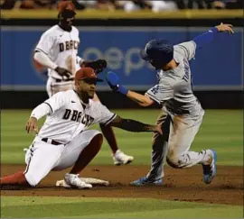  ?? Norm Hall Getty Images ?? TREA TURNER of the Dodgers is tagged out by Arizona’s Ketel Marte while attempting to steal second base in the third inning of the Diamondbac­ks’ win.