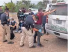  ?? JOHN MOORE/GETTY IMAGES ?? A transport officer searches migrants before busing them to a processing center after they crossed the border from Mexico on April 13 in La Joya, Texas.