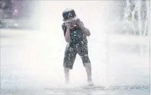  ?? GRAHAM HUGHES
THE CANADIAN PRESS ?? Samuel Bedard, 7, runs through a water fountain as he beats the heat in Montreal.
