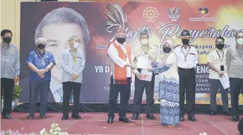  ?? ?? Awang Tengah (fourth left) presents land title to a recipient from Kuala Tatau as (from left) Majang, Sikie, Talib, Awang Zamhari, Mohd Asfia, Zunica and Jack look on.