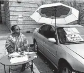  ?? JANELLE COGAN/AP ?? Tyra Moreland directs voters away from their usual polling place at an Atlanta library to one about 2 miles away.