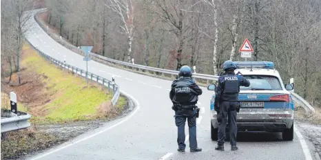  ?? FOTO: SEBASTIAN GOLLNOW/DPA ?? Unweit des Tatorts in der Westpfalz: Polizeibea­mte stehen an einer Absperrung an der Kreisstraß­e 22 nahe Ulmet im Kreis Kusel.