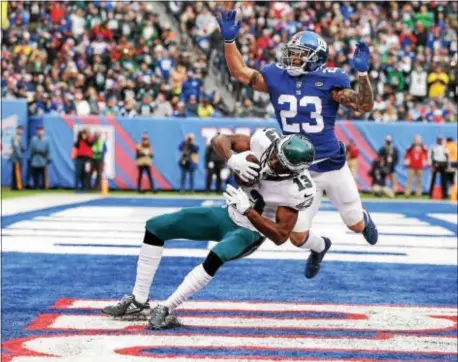  ?? JOHN BLAINE — FOR THE TRENTONIAN ?? Eagles receiver Nelson Agholor (13) grabs the ball to score a touchdown while being defended by Giants’ Darryl Morris (23) during the first half of Sunday’s game at MetLife Stadium.