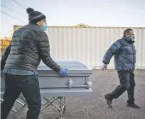  ?? RAMSAY DE GIVE/FOR THE WASHINGTON POST ?? Valley Ridge Mortuary owner Michael A. Begay, left, pushes a coffin toward a hearse for transporta­tion in January to a burial site in Tuba City, Ariz., on the Navajo Nation. Navajo President Jonathan Nez said tribal leaders have worked hard to overcome the ‘distrust in Indian Country of government’ and science.