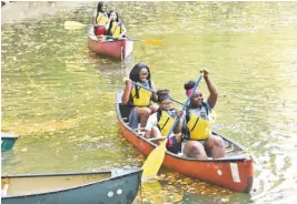  ?? STAFF PHOTO BY TIM BARBER ?? Denariya Johnson, back left, Shateyahni Robinson, center boat, and Jakaela Moore begin their canoe journey Monday as members of the Outdoor Leadership Club at The Howard School enjoy an outing on the North Chickamaug­a Creek recently at Spangler Farm in...