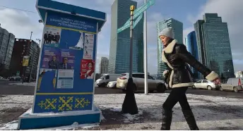  ?? — AFP photo ?? A pedestrian walks past campaign posters of presidenti­al candidates in Astana, ahead of Kazakhstan’s presidenti­al elections.