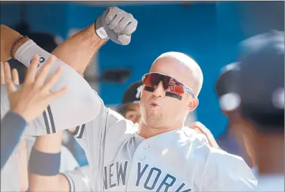  ?? COLE BURSTON/GETTY ?? Brett Gardner bangs forearms with teammates after his two homers against the Blue Jays gave him 25, four more than his previous high.