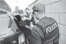  ?? JOHN MOORE, GETTY IMAGES ?? Authoritie­s detain an immigrant in 2015 in L.A. New rules require that detainees be held until their cases are resolved.