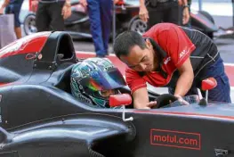  ??  ?? Strapping into the Formula 4 car while getting last-minute instructio­ns on starting the engine and operating the sequential paddle-shift transmissi­on