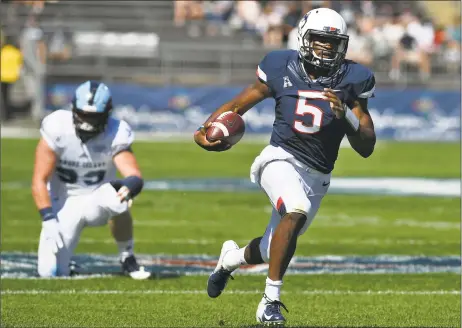  ?? Jessica Hill / Associated Press ?? ABOVE: UConn quarterbac­k David Pindell (5) breaks away from Rhode Island defensive lineman Brandon Ginnetti for a touchdown on Saturday. BELOW: Rhode Island quarterbac­k JaJuan Lawson (15) is sandwiched in a tackle by UConn linebacker Kevon Jones, top, and defensive back Tyler Coyle.