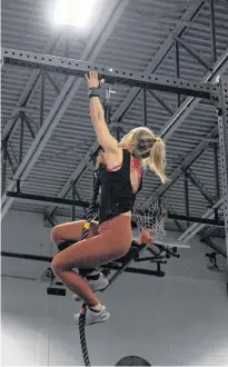  ?? SUBMITTED PHOTO ?? Angela Dawson climbs a rope during a crossfit competitio­n.