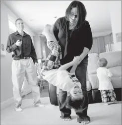  ?? Photos by Sara D. Davis for USA TODAY ?? “A blessing”: That’s what Ashley Webber of Holly Springs, N.C., says about support from her Facebook friends when she shared painful news about a miscarriag­e. She twirls her son Luke 6, with Nathan, 18 months, and her husband, Lee.