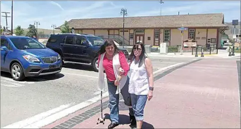  ?? COURTESY OF HENSON FAMILY ?? Twins Kelly Henson Arciszewsk­i, left, and Tracy Henson Wills, are pictured here in 2016, walking across Tehachapi Boulevard at Green Street. In 1972 the twins were 11 years old when they were hit by a car in the same intersecti­on. Five days later the Tehachapi City Council voted to create a four-way stop there.