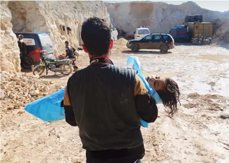  ??  ?? A man carries the body of a dead child, after what rescue workers described as a suspected gas attack in the town of Khan Sheikhoun in opposition-held Idlib, Syria.