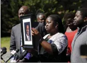  ?? DANIEL SANGJIB MIN — RICHMOND TIMES-DISPATCH VIA AP ?? Caroline Ouko, mother of Irvo Otieno, holds a portrait of her son with attorney Ben Crump, left, and her older son, Leon Ochieng, at the Dinwiddie Courthouse in Dinwiddie, Va., on March 16. She said Otieno, who died in a state mental hospital March 6, was “brilliant and creative and bright.”