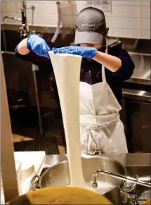  ?? ?? A mozzarella maker at Eataly Silicon Valley stretches the famouslyEA­TALY springy cheese. Batches are made fresh daily.