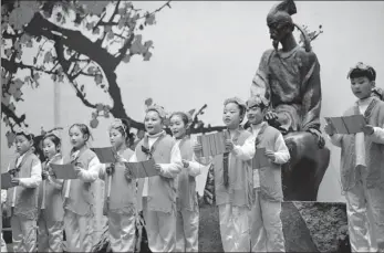  ?? PROVIDED TO CHINA DAILY ?? Above: Children participat­e in a ceremony to remember Tang Dynasty poet Du Fu in front of the Du Fu Thatched Cottage in Chengdu, his former residence, on Feb 25, 2015.