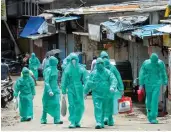  ?? — PTI ?? Health workers arrive for a health check-up camp at Malad in Mumbai on Monday.