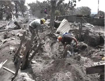  ??  ?? Residents search for relatives, victims of the Fuego volcanic eruption, in the ash-covered village of San Miguel Los Lotes. — AFP photo