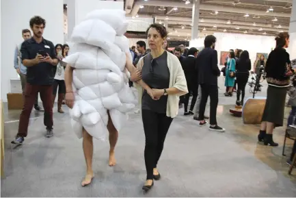  ?? (Carolina A. Miranda/Los Angeles Times/TNS) ?? A PERFORMANC­E ARTIST covered in pillows makes his way through the Zona Maco art fair in Mexico City in February. The fair, which has been around since 2002, has been gaining a higher profile in recent years.