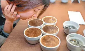  ?? PHOTOS BY CAI YANG / XINHUA ?? Top: Workers prepare coffee for guests at the Chongqing Coffee Exchange on April 13. Above: A guest smells coffee at the coffee trading center in Chongqing.