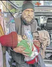  ??  ?? An elderly man carries an injured child to Government Medical College Hospital, Jammu, on Saturday.