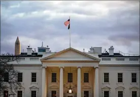  ?? SAMUEL CORUM / THE NEW YORK TIMES ?? The American flag flies over the White House as the sun sets over Washington. The White House is a classical style piece of architectu­re, inspired by Greek and Roman buildings.