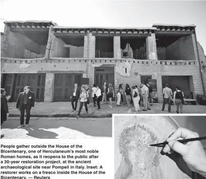  ??  ?? People gather outside the House of the Bicentenar­y, one of Herculaneu­m’s most noble Roman homes, as it reopens to the public after a 30-year restoratio­n project, at the ancient archaeolog­ical site near Pompeii in Italy. Inset: A restorer works on a fresco inside the House of the Bicentenar­y. — Reuters