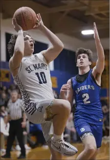  ?? LIBBY O’NEILL — BOSTON HERALD ?? St. Mary’s player Rowan Merryman rises up to the hoop and avoids Dover-Sherborn’s Jonathan Windle during Friday’s state tournament battle.