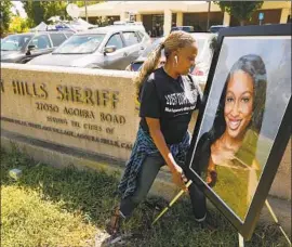  ?? Al Seib Los Angeles Times ?? KIM HOWARD puts up a photo of Mitrice Richardson at the Calabasas sheriff ’s station on Tuesday for a memorial on the 10th anniversar­y of her disappeara­nce.