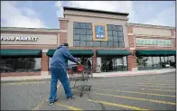  ?? AP/JULIO CORTEZ ?? A shopper pushes a cart toward the entrance of an Aldi food market last month in East Rutherford, N.J. The discount grocery chain is spending more than $3 billion to open more U.S. stores.