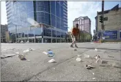  ?? MIKE DE SISTI — MILWAUKEE JOURNAL-SENTINEL VIA AP ?? Victor Prado, with MKE Downtown, clears debris near the corner of North Water Street and East Juneau Avenue in Milwaukee, Saturday where multiple people were shot and injured late Friday in Milwaukee’s downtown bar district after the Milwaukee Bucks playoff game.