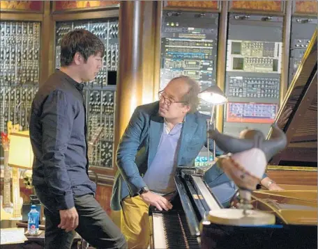  ?? DreamWorks ?? CHINESE PIANIST Lang Lang, left, and Hans Zimmer confer during a brief recording session of piano solos in Zimmer’s studio.