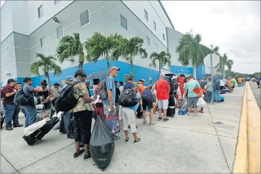  ?? [GERALD HERBERT/THE ASSOCIATED PRESS] ?? People work their way down a line to enter the Germain Arena in Estero, Florida, south of Fort Myers. The arena, home to a minor league hockey team, is being used as a shelter as Hurricane Irma threatens.