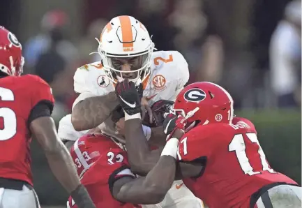  ?? AP ?? Tennessee quarterbac­k Jarrett Guarantano (2) is stopped short of a first down by Georgia linebacker­s Monty Rice (32) and Jermaine Johnson (11).