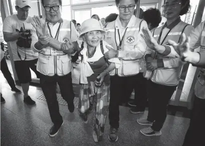  ?? Associated Press ?? ■ South Korean Lee Geum-seom, 92, second from left, is helped by Red Cross officials Sunday as she arrives to take part in family reunions with her North Korean family members at a hotel in Sokcho, South Korea.