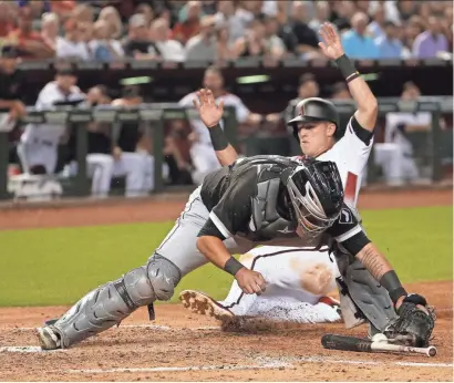  ?? MICHAEL CHOW/AZCENTRAL SPORTS ?? White Sox catcher Omar Narvaez drops the ball as the Diamondbac­ks’ Jake Lamb slides in safely at home during the sixth inning Monday night at Chase Field. The Diamondbac­ks beat the White Sox 5-1.