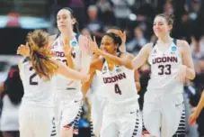  ??  ?? UConn players celebrate after cruising into the Elite Eight with a 60-point win overMissis­sippi State. Jessica Hill, The Associated Press