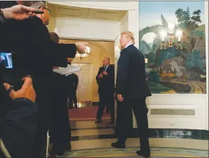  ?? AP PHOTO ?? President Donald Trump talks with reporters as he leaves the room after signing a Presidenti­al Memorandum imposing tariffs and investment restrictio­ns on China in the Diplomatic Reception Room of the White House, Thursday.