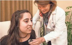  ?? GARY PORTER / FOR MILWAUKEE JOURNAL SENTINEL ?? Joan Kiely, a nurse practition­er with RemedyNow, demonstrat­es patient care on Hana Siddiqui at the Siddiqui home in Brookfield.