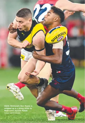  ?? Picture: GETTY IMAGES ?? OUCH: Richmond’s Dion Prestia is wrapped up in a strong tackle by Melbourne’s Kysaiah Pickett.