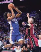  ?? AP ?? The 76ers’ Tyrese Maxey, left, goes up for a shot against the Heat’s Tyler Herro during the second half on
Friday in Philadelph­ia.