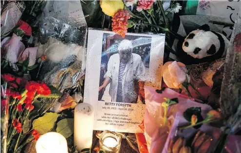  ?? GALIT RODAN / THE CANADIAN PRESS ?? A photo of Betty Forsyth rests in the rain at a vigil on Yonge Street on Tuesday.