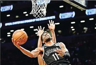  ?? GETTY IMAGES/AFP ?? Kyrie Irving of the Brooklyn Nets goes in for a layup during the first half of their game against the Minnesota Timberwolv­es at Barclays Centre on Wednesday in the Brooklyn borough of New York City.