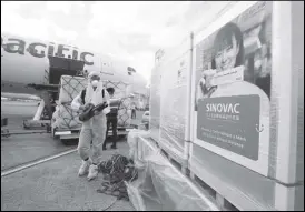  ?? KJ ROSALES ?? Airport personnel unload and disinfect a cargo of Sinovac vaccines at the Ninoy Aquino Internatio­nal Airport Terminal 2 yesterday.
