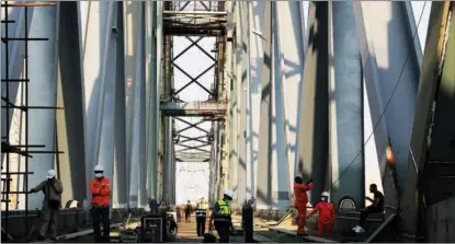  ?? WANG DONGZHEN / XINHUA ?? Workers at the constructi­on site of the Suez Canal Railway Bridge in Ismailia, Egypt, on June 5. Chinese companies have been pushing forward in upgrading this bridge.