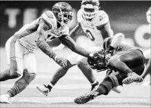  ?? DARRYL DYCK THE CANADIAN PRESS ?? B.C. Lions quarterbac­k Travis Lulay, right, tumbles ahead to avoid a tackle from Saskatchew­an Roughrider­s’ Samuel Eguavoen, left, during the second half of a CFL game in Vancouver on Saturday.