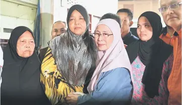  ?? — Bernama photo ?? Dr Wan Azizah paying a visit to Che Yang at Kampung Baru Sungai Kob who lost her husband Johari Bakar and youngest daughter Nor Suri when they drowned in flash floods.