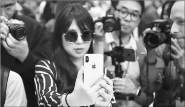  ??  ?? Taking photos as a woman tests out a new iPhone X during a media event at Apple’s new headquarte­rs in Cupertino in September. — AFP file photo